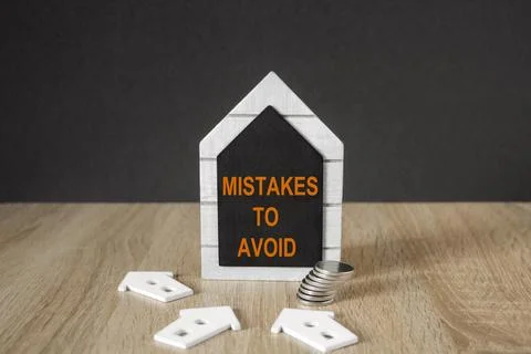 Concept red words MISTAKES TO AVOID on black blackboard. Stock Photos
