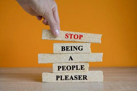 Concept red words Stop Being A People Pleaser on brick blocks. Stock Photos