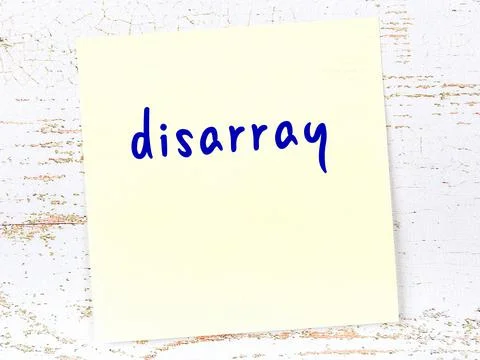 Concept of reminder about disarray. Yellow sticky sheet of paper on wooden wa Stock Photos