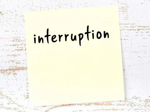 Concept of reminder about interruption. Yellow sticky sheet of paper on woode Stock Photos