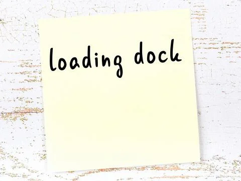 Concept of reminder about loading dock. Yellow sticky sheet of paper on woode Foto stock