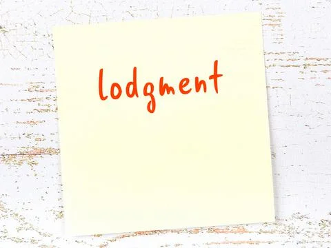 Concept of reminder about lodgment. Yellow sticky sheet of paper on wooden wa Stock Photos