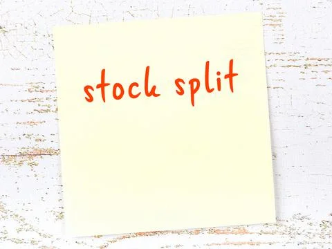 Concept of reminder about stock split. Yellow sticky sheet of paper on wooden Foto stock