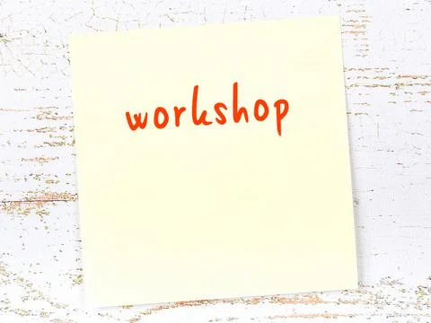 Concept of reminder about workshop. Yellow sticky sheet of paper on wooden wa 스톡 사진