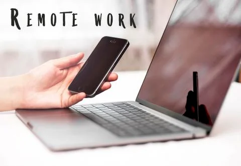 The concept of remote work. Computer and hand with phone on desktop  Stock Photos