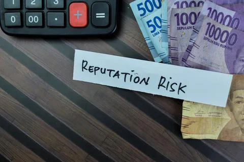 Concept of Reputation Risk write on sticky notes isolated on Wooden Table. Photos