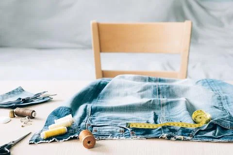 The concept of reusing old recyclable materials. Sewing and repair denim clothes Stock Photos