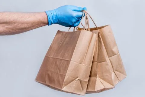 The concept of safe delivery in close-up. the courier's hand in protective me Stock Photos