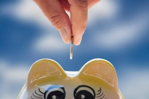 Concept saving  hand putting a coin into piggy bank Stock Photos