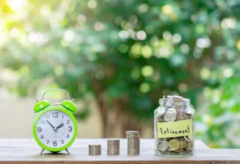 Concept saving for retirement.Coins stack and alarm clock. Stock Photos