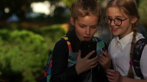 Concept of school friendship. Two teenage girls. In the summer of the city park Stock Footage