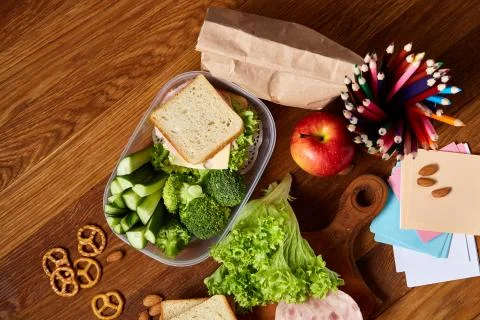 Concept of school lunch break with healthy lunch box and school supplies on Stock Photos