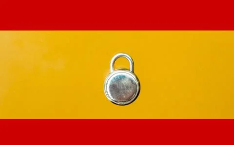 Concept Of Second Lockdown in Spain. Real padlock placed on top of flag of Sp Stock Photos