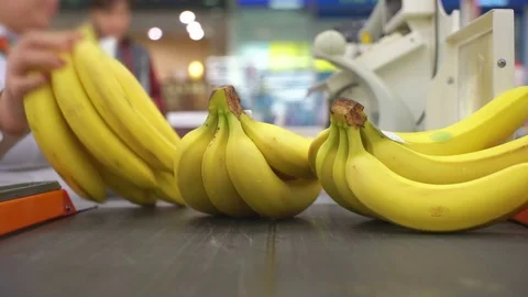 Concept shopping in supermarket. Cashier scans purchase bananas of a red laser Stock Footage