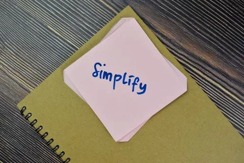 Concept of Simplify Reminder write on sticky notes isolated on Wooden Table. Stock Photos