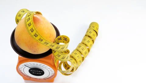 Concept of slimming regime. scale, measuring tape, peach. Stock Photos