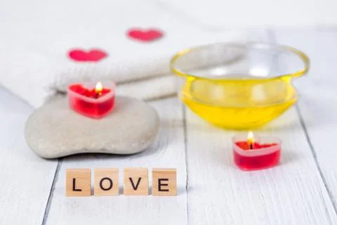 The concept of a Spa on Valentine's Day. Burn red heart-shaped candles, stones Stock Photos