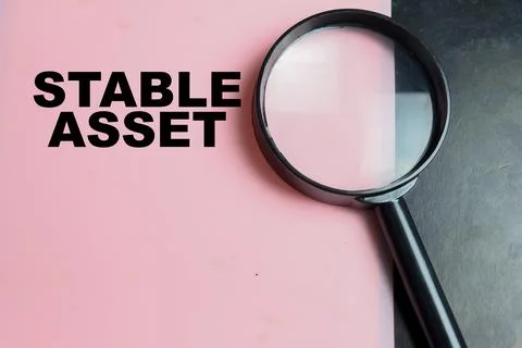 Concept of stable asset write on color background with magnifying glass. Stock Photos