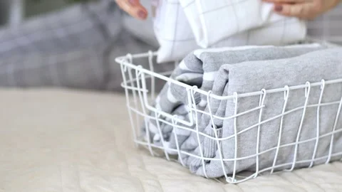 The concept of storage and organization of space. Women's hands neatly fold T Stock Footage 250935881
