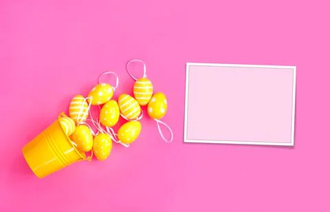 Concept sweet Easter symbols colored yellow eggs and buckets on pink paper ba Stock Photos