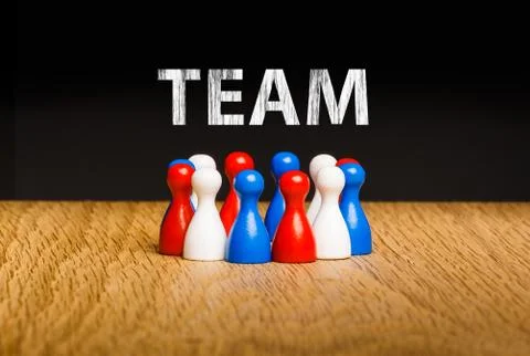 Concept for team, teamwork with white chalk text. Red white blue pawn figures Stock Photos