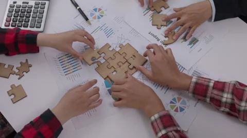Concept of teamwork and partnership. Hands join puzzle pieces in the office.. Stock Footage 336932297