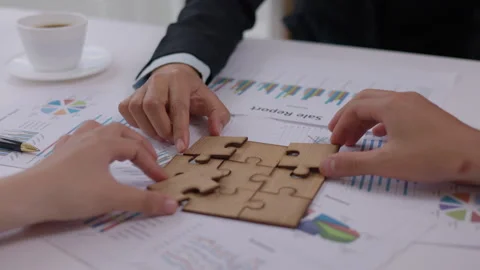 Concept of teamwork and partnership. Hands join puzzle pieces in the office.. Video stock 336932306