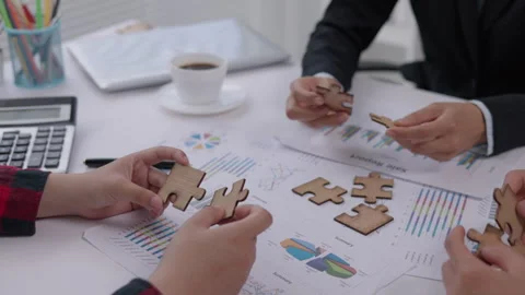 Concept of teamwork and partnership. Hands join puzzle pieces in the office.. Stock Footage 336932309