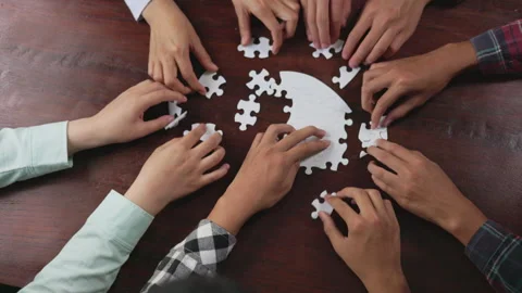 Concept of teamwork and partnership. Hands join puzzle pieces in the office.. Video stock 336932344