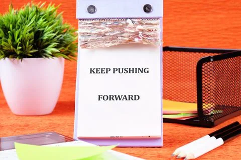 Concept text KEEP PUSHING FORWARD written on the calendar page among the stat Stock Photos