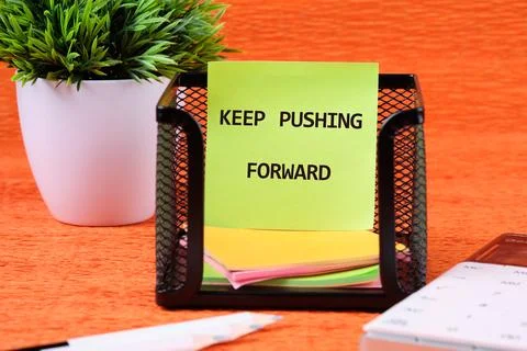 Concept text KEEP PUSHING FORWARD written on colorful stickers in a black mes Stock Photos