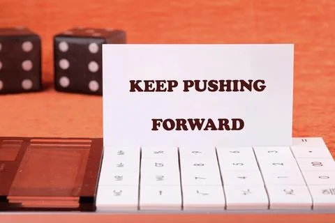 Concept text KEEP PUSHING FORWARD on a business card with game cubes in the b Stock Photos