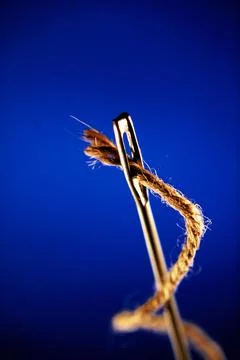 Concept, thread and needle against blue background 写真素材