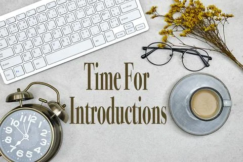Concept of Time for Introductions, desktop: keyboard with alarm clock and cup of Stock Photos