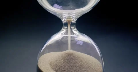 Concept of turning back time. Hourglass with grains of sand on a dark backg.. Video stock 285945094