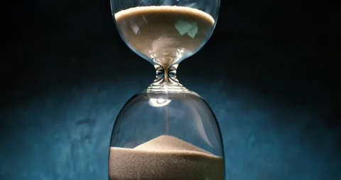 Concept of turning back time. Hourglass with grains of sand on a dark backg.. Stock Footage 296384734