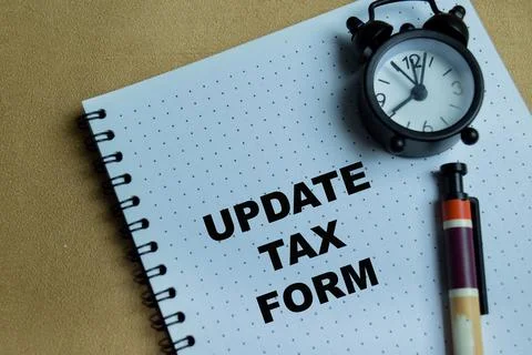Concept of update tax form write on book isolated on Wooden Table. Stock Photos