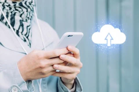 The concept of uploading data to the Internet cloud system. Girl holds a smar Stock Photos