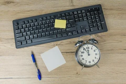 The concept of urgent deadline at work. Keyboard, clock, pen and blank paper Stock Photos