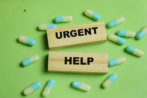 Concept of urgent help with pills text on wooden blocks. Stock Photos