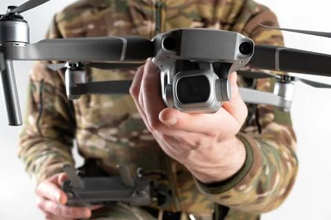 Concept of using drones in modern war. Close-up of drone in hands of a soldie Stock Photos