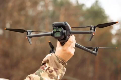 Concept of using drones in modern warfare. Close-up of a drone in hands of a  Stock Photos