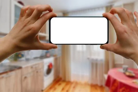 The concept of using a mobile phone at home. Blank white screen for your imag Stock Photos