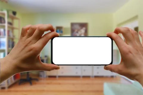 The concept of using a mobile phone at home. Blank white screen for your imag Stock Photos