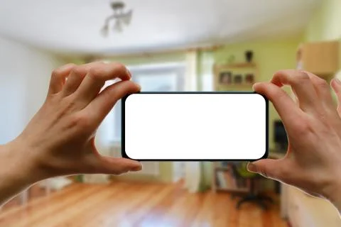 The concept of using a mobile phone at home. Blank white screen for your imag Stock Photos
