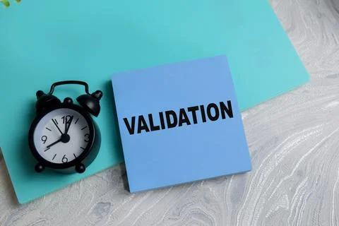 Concept of validation write on sticky notes isolated on Wooden Table. Stock Photos