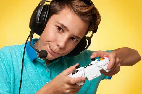 The concept of virtual and computer games. A teenage boy in a blue t-shirt an Stock Photos