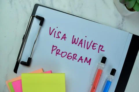 Concept of Visa Waiver Program write on paperwork isolated on Wooden Table. Stock Photos