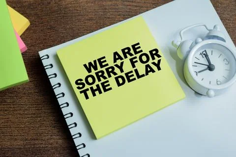 Concept of we are sorry for the delay write on sticky notes Stock Photos