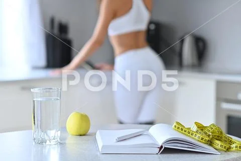The concept of weight loss, diet, slim girl in white kitchen counting calorie Stock Photos